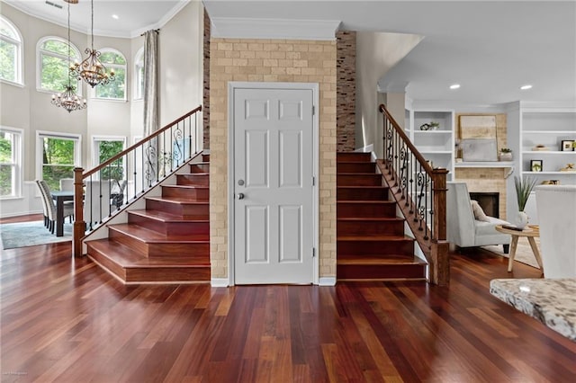 2990 Hearthstone Dr, Cumming, GA 30041 - foyer entrance featuring crown molding, stairway, a chandelier, wood finished floors, and healthy amount of natural light