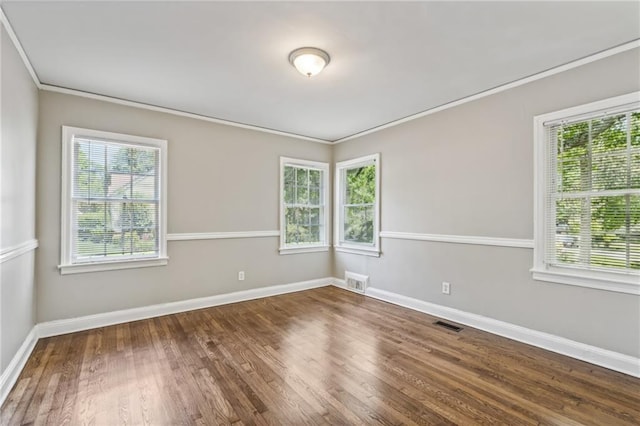 unfurnished room with dark hardwood / wood-style floors, plenty of natural light, and ornamental molding