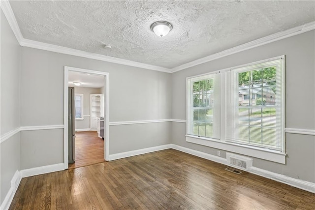 spare room with a textured ceiling, dark hardwood / wood-style floors, and crown molding