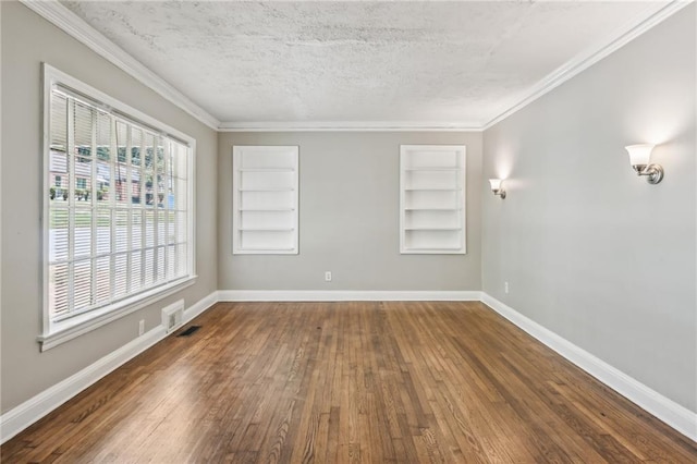 empty room featuring a textured ceiling, built in shelves, and dark hardwood / wood-style floors