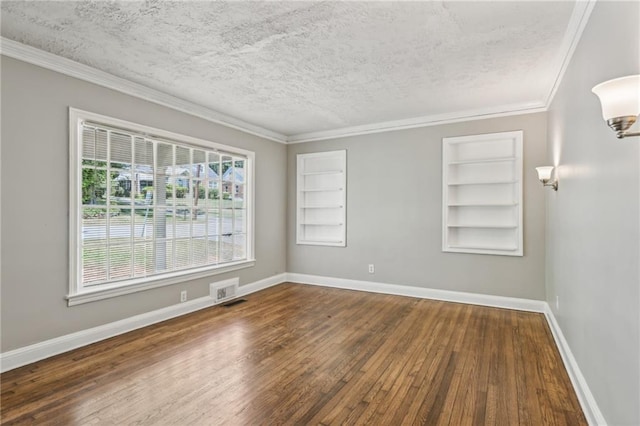 unfurnished room with hardwood / wood-style floors, a textured ceiling, built in features, and crown molding