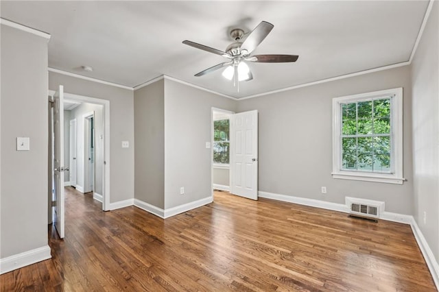 empty room featuring dark hardwood / wood-style floors, ceiling fan, and ornamental molding