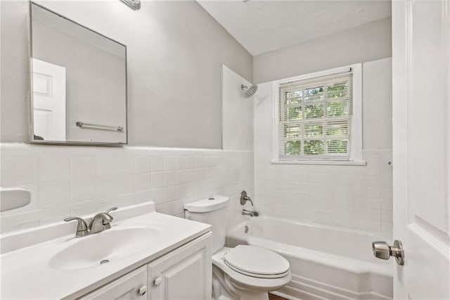 full bathroom with shower / bathing tub combination, vanity, toilet, and tile walls