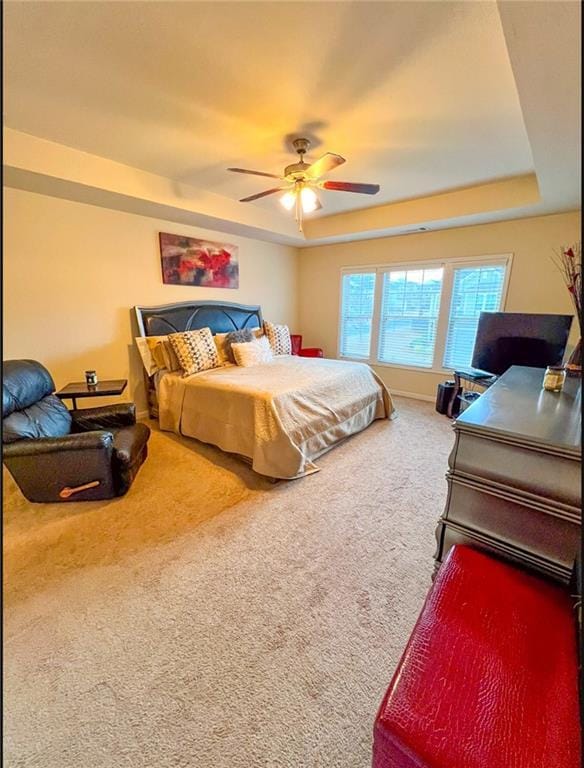 bedroom featuring carpet, ceiling fan, and a tray ceiling