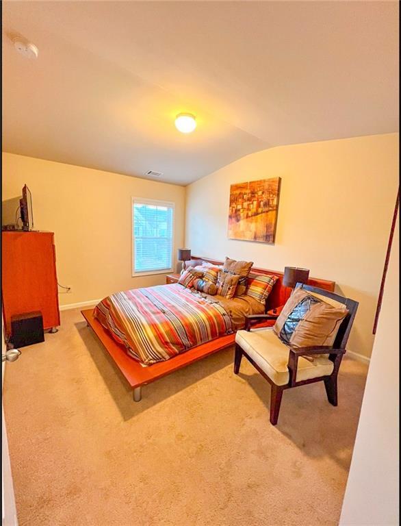 bedroom with lofted ceiling and carpet floors