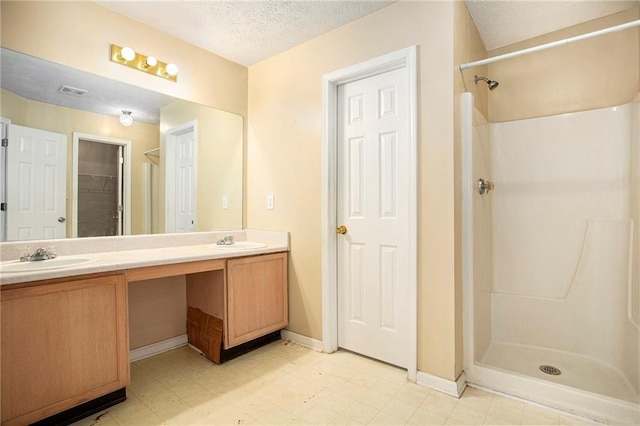 4103 Kingship Dr, Ellenwood, GA 30294 - full bathroom featuring a stall shower, double vanity, a textured ceiling, baseboards, and tile patterned floors