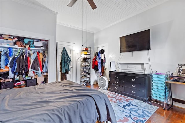 bedroom featuring a ceiling fan, a closet, wood-type flooring, and ornamental molding