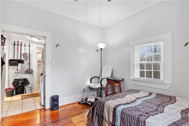 bedroom with ornamental molding, baseboards, and hardwood / wood-style flooring