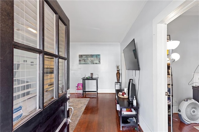 interior space featuring crown molding, baseboards, and wood finished floors