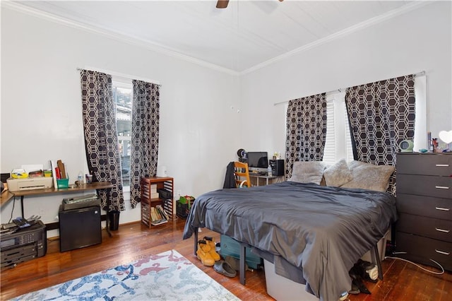 bedroom with a ceiling fan, wood finished floors, and ornamental molding