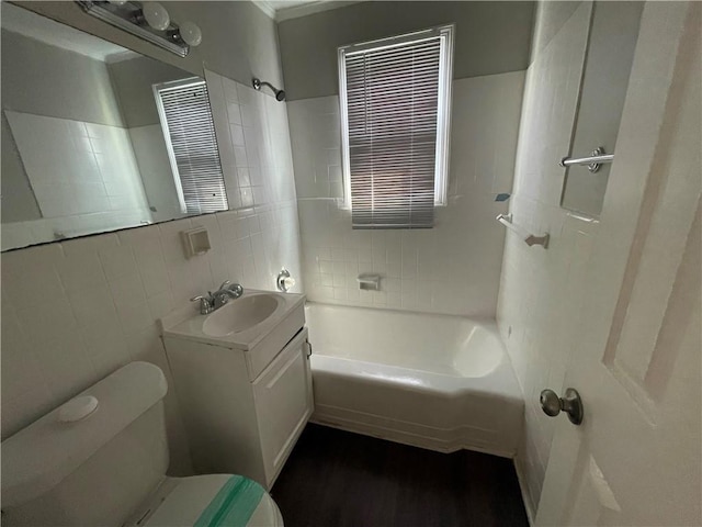 1440 Kenilworth Dr SW, Atlanta, GA 30310 - full bathroom featuring toilet, tile walls, vanity, shower / bathtub combination, and wood finished floors