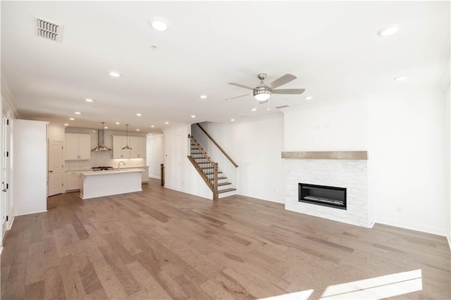 350 Olmstead Way Unit 29, Alpharetta, GA 30022 - unfurnished living room with recessed lighting, stairway, light wood finished floors, a ceiling fan, and a stone fireplace