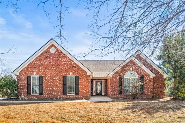 view of front of home featuring a front lawn and brick siding