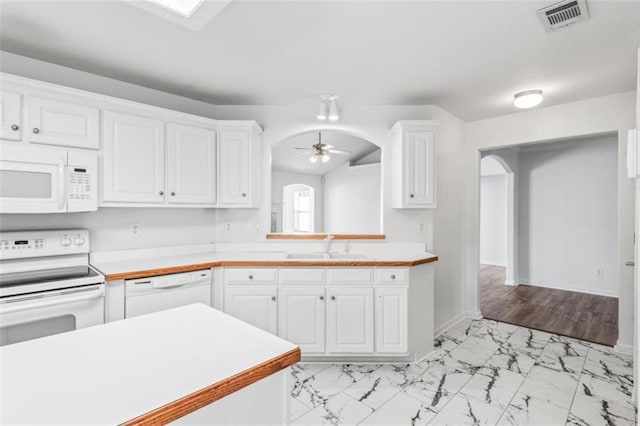 kitchen with light countertops, white appliances, white cabinetry, and arched walkways