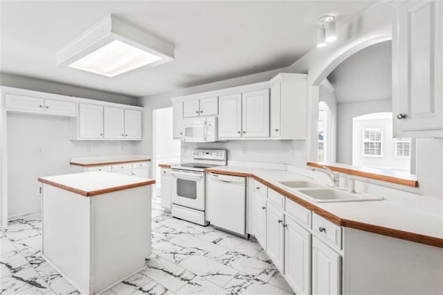 kitchen featuring white appliances, white cabinets, a kitchen island, marble finish floor, and light countertops