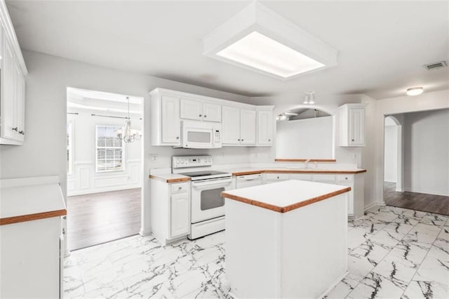 kitchen with marble finish floor, light countertops, visible vents, white cabinets, and white appliances