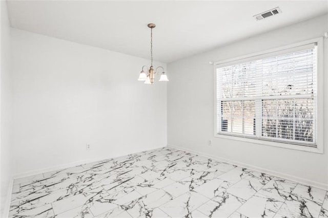 empty room with marble finish floor, visible vents, a notable chandelier, and baseboards