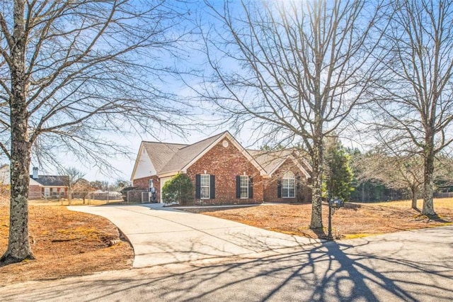 traditional home featuring driveway and brick siding