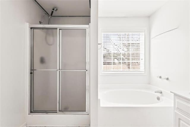 bathroom with a shower stall, vanity, and a bath