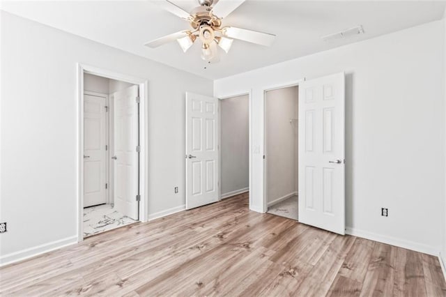 unfurnished bedroom with light wood-style flooring, visible vents, and baseboards