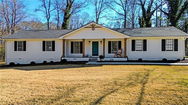 ranch-style home featuring a porch, a garage, and a front lawn