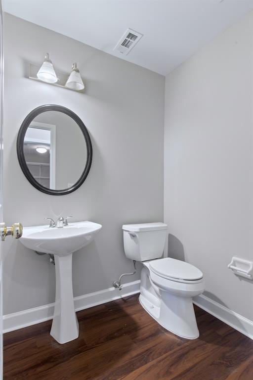 bathroom with wood-type flooring and toilet