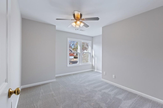 empty room featuring ceiling fan and light carpet