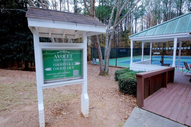 view of community featuring a deck and tennis court