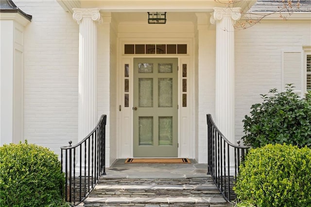 entrance to property featuring brick siding