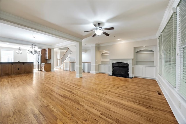 4742 Legacy Cove Ln, Smyrna, GA 30126 - unfurnished living room featuring a fireplace, a ceiling fan, light wood finished floors, a chandelier, and built in shelves