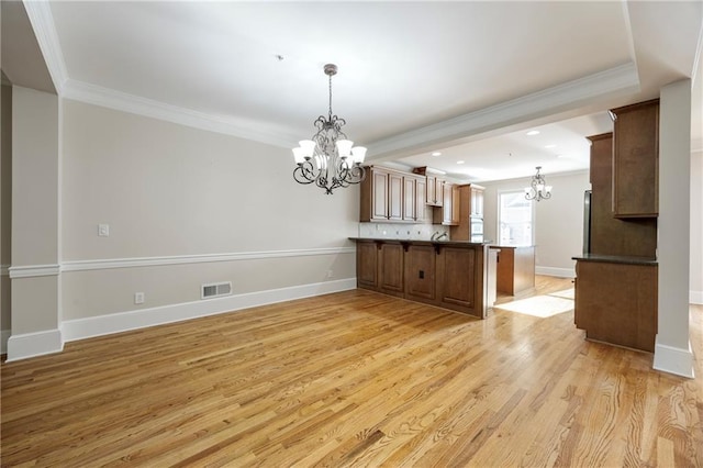 4742 Legacy Cove Ln, Smyrna, GA 30126 - kitchen featuring a chandelier, crown molding, a peninsula, light wood-style floors, and pendant lighting