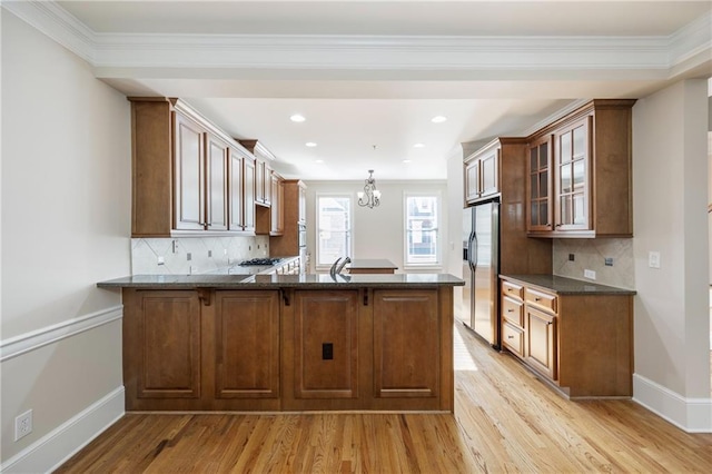 4742 Legacy Cove Ln, Smyrna, GA 30126 - kitchen with stainless steel fridge, a peninsula, light wood finished floors, glass insert cabinets, and a chandelier