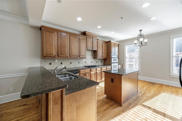 4742 Legacy Cove Ln, Smyrna, GA 30126 - kitchen featuring crown molding, a kitchen island, backsplash, gas cooktop, and dark stone counters
