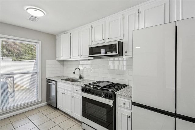 4322 Idlewood Ln, Tucker, GA 30084 - kitchen with visible vents, range with gas stovetop, a sink, stainless steel dishwasher, and freestanding refrigerator