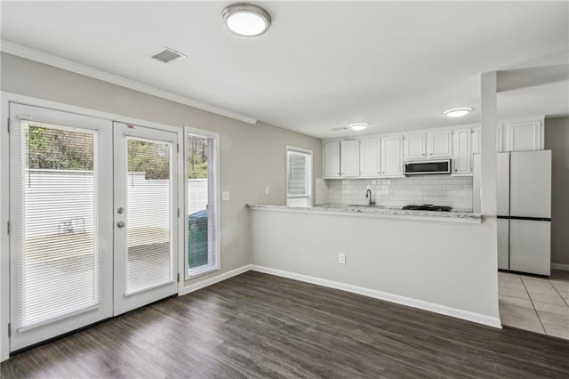 4322 Idlewood Ln, Tucker, GA 30084 - kitchen with freestanding refrigerator, a peninsula, french doors, and stainless steel microwave