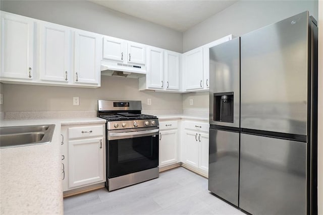 2709 Heathrow Dr, Lawrenceville, GA 30043 - kitchen with appliances with stainless steel finishes, under cabinet range hood, white cabinets, light countertops, and light wood-type flooring