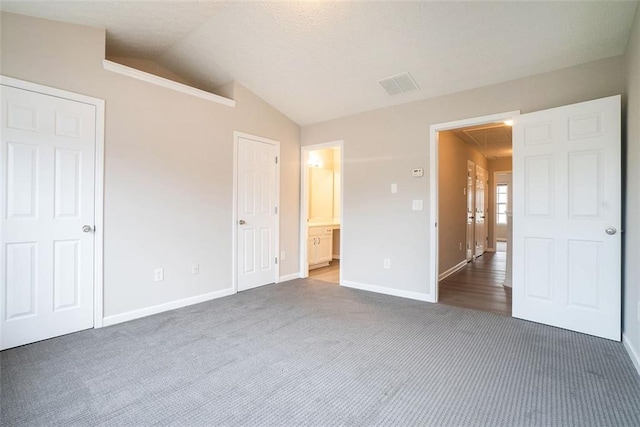 2709 Heathrow Dr, Lawrenceville, GA 30043 - unfurnished bedroom featuring carpet flooring, lofted ceiling, baseboards, and ensuite bathroom