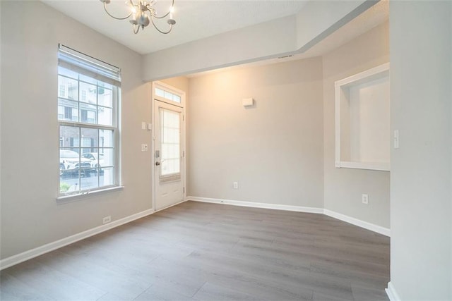 2709 Heathrow Dr, Lawrenceville, GA 30043 - spare room with a chandelier, dark wood finished floors, and baseboards