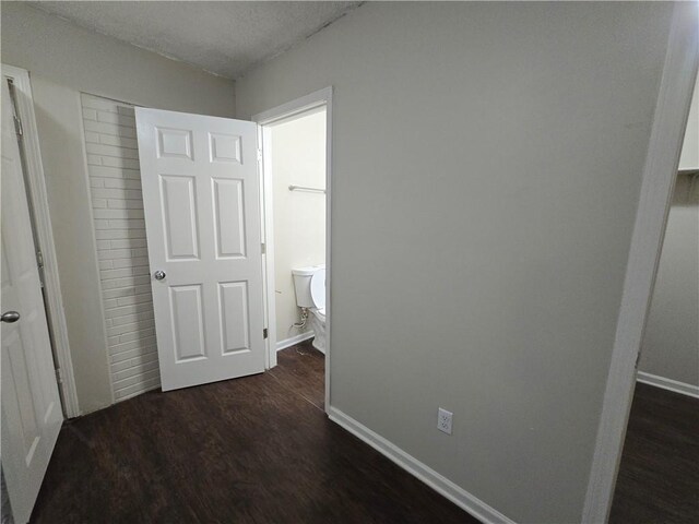 hallway with dark hardwood / wood-style floors and a textured ceiling