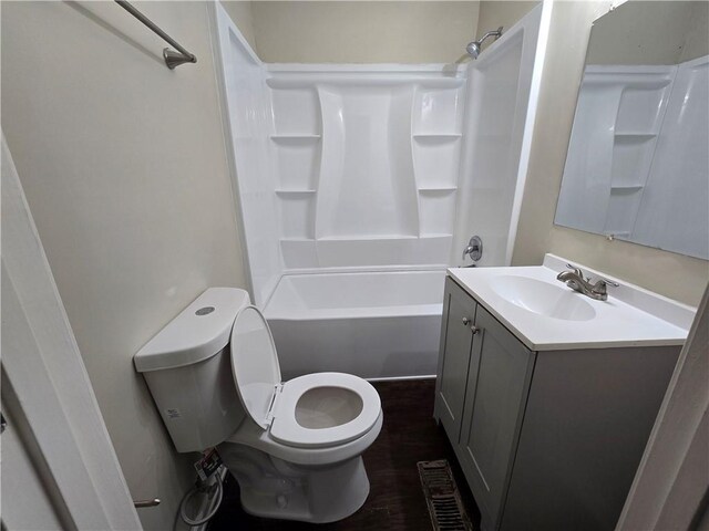 full bathroom with hardwood / wood-style flooring, vanity,  shower combination, and toilet