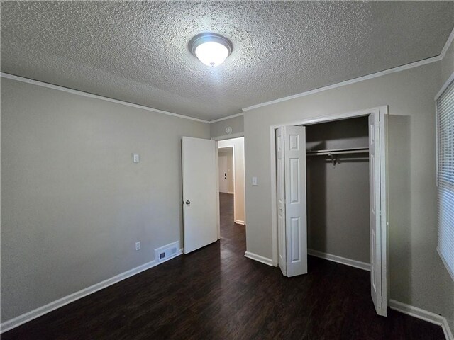 unfurnished bedroom featuring crown molding, dark hardwood / wood-style flooring, a textured ceiling, and a closet