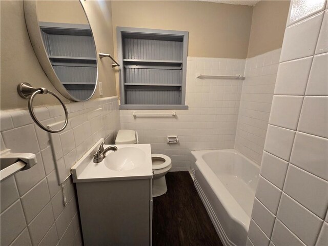 bathroom with a bath, wood-type flooring, toilet, vanity, and tile walls