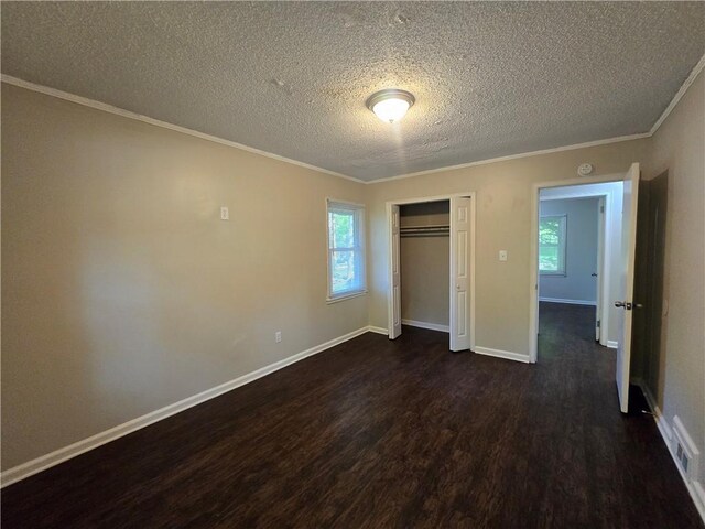 unfurnished bedroom featuring a textured ceiling, dark hardwood / wood-style flooring, a closet, and ornamental molding