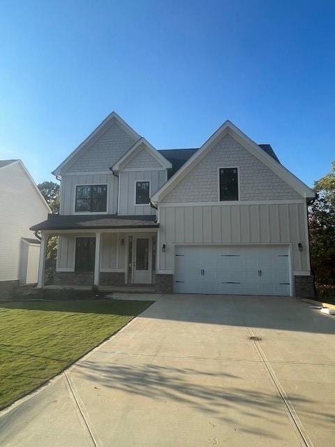 craftsman-style home with driveway, board and batten siding, covered porch, a front yard, and a garage