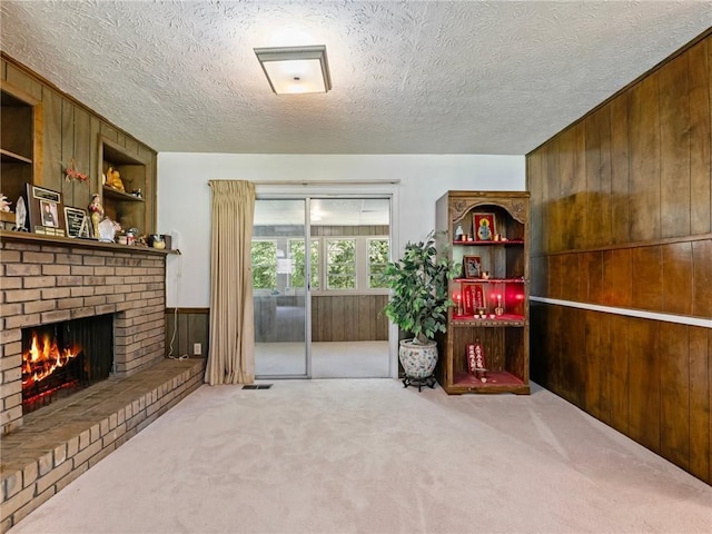 784 San Miguel Dr, Stone Mountain, GA 30083 - sitting room featuring wood walls, carpet, a fireplace, and a textured ceiling