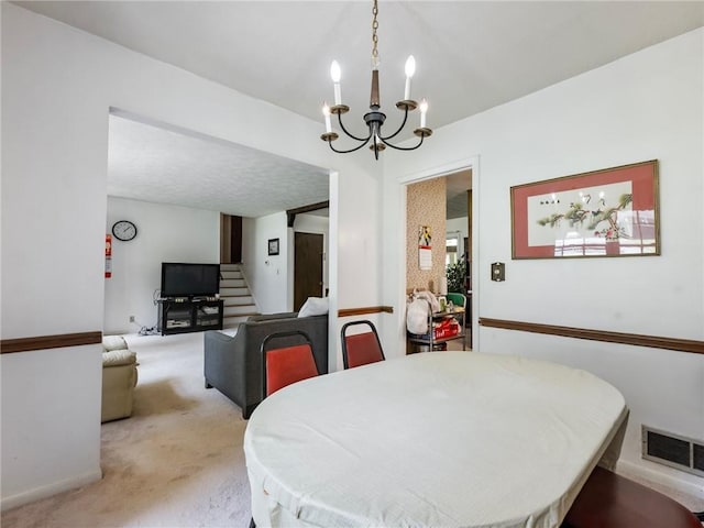 784 San Miguel Dr, Stone Mountain, GA 30083 - dining space featuring a chandelier, light colored carpet, and stairs