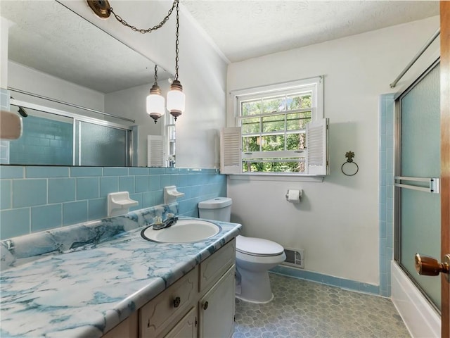 784 San Miguel Dr, Stone Mountain, GA 30083 - bathroom with vanity, a textured ceiling, combined bath / shower with glass door, tasteful backsplash, and tile patterned floors
