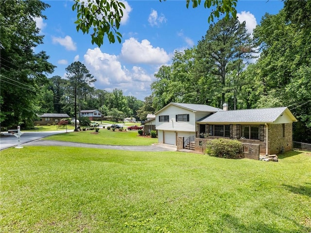 784 San Miguel Dr, Stone Mountain, GA 30083 - split level home featuring brick siding, driveway, an attached garage, a front lawn, and a chimney