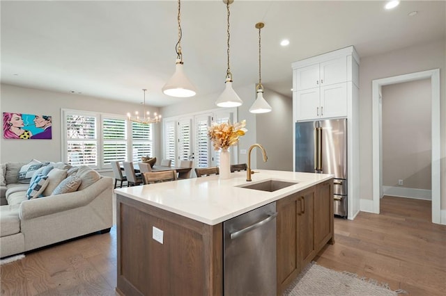 920 Wemberley Ln, Marietta, GA 30064 - kitchen with appliances with stainless steel finishes, a sink, a chandelier, open floor plan, and white cabinets