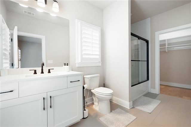 920 Wemberley Ln, Marietta, GA 30064 - bathroom with vanity, toilet, baseboards, a spacious closet, and combined bath / shower with glass door